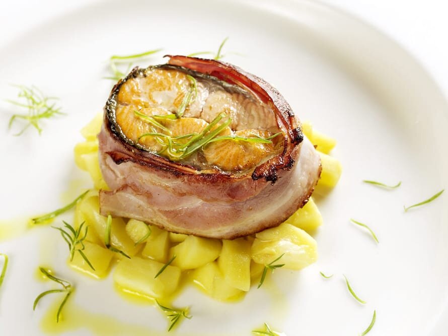 Salmão enrolado em bacon sobre funcho e maçã