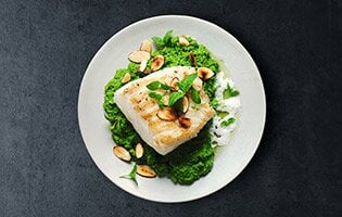 Skrei grelhado com puré de ervilhas, óleo de hortelã e espuma de amêndoa