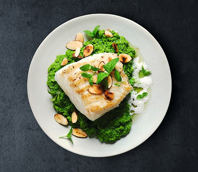 Skrei grelhado com puré de ervilhas, óleo de hortelã e espuma de amêndoa